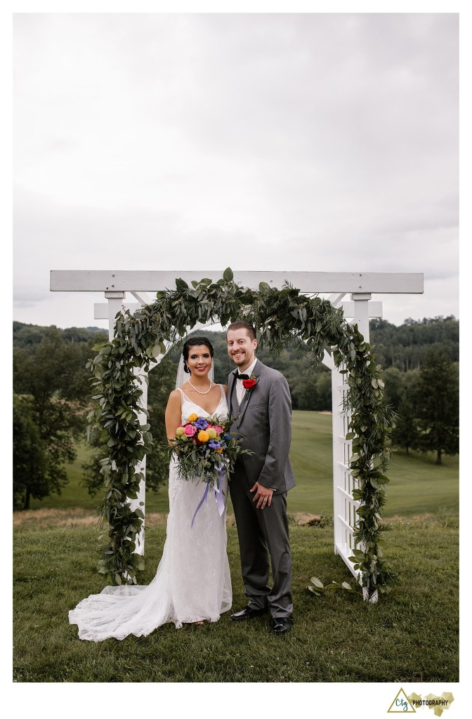 bride and groom under arch
