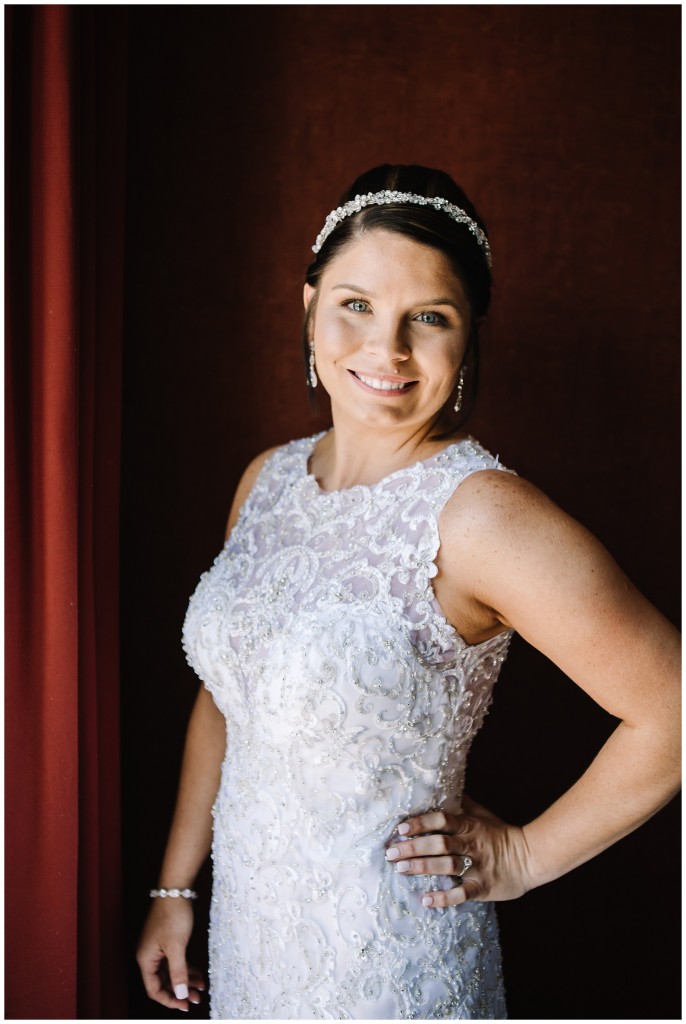 bride posing next to a window